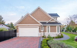 A beautiful modern craftsman-style home with a brick driveway and manicured lawn, representing a dream home purchase.