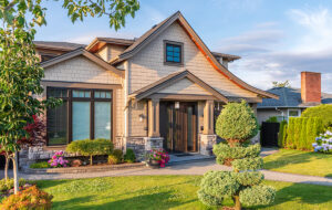 Modern suburban home with landscaped yard and stone pillars, representing the $400K home purchase discussed in the mortgage affordability guide.